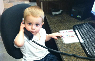 Child using a phone at an office desk