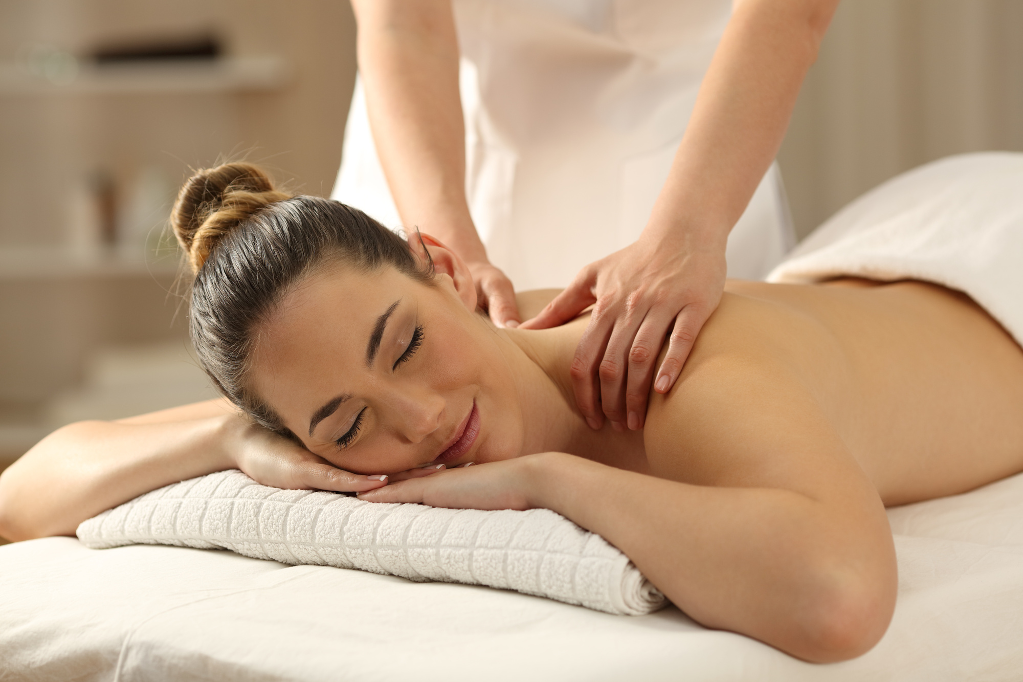 Woman enjoying a relaxing back massage at spa.