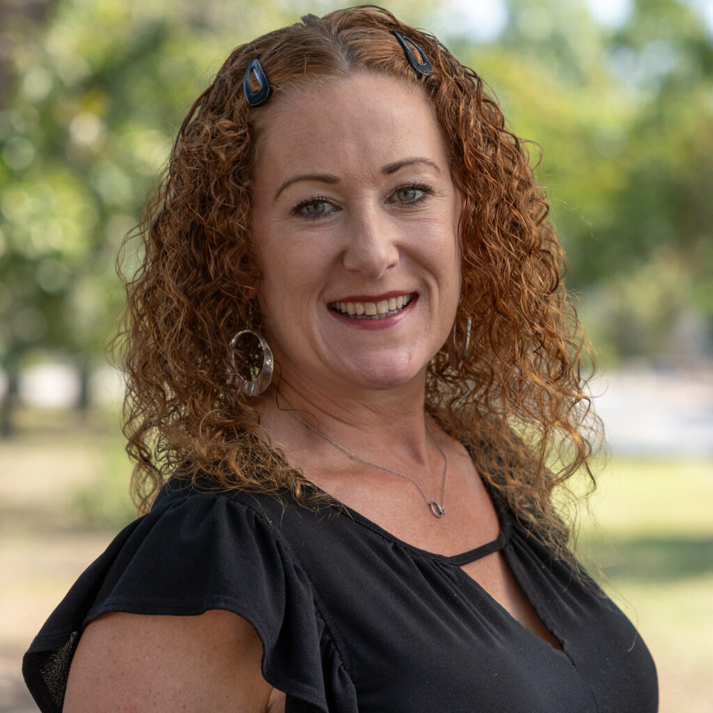 stephanie mt Smiling woman outdoors with curly hair.